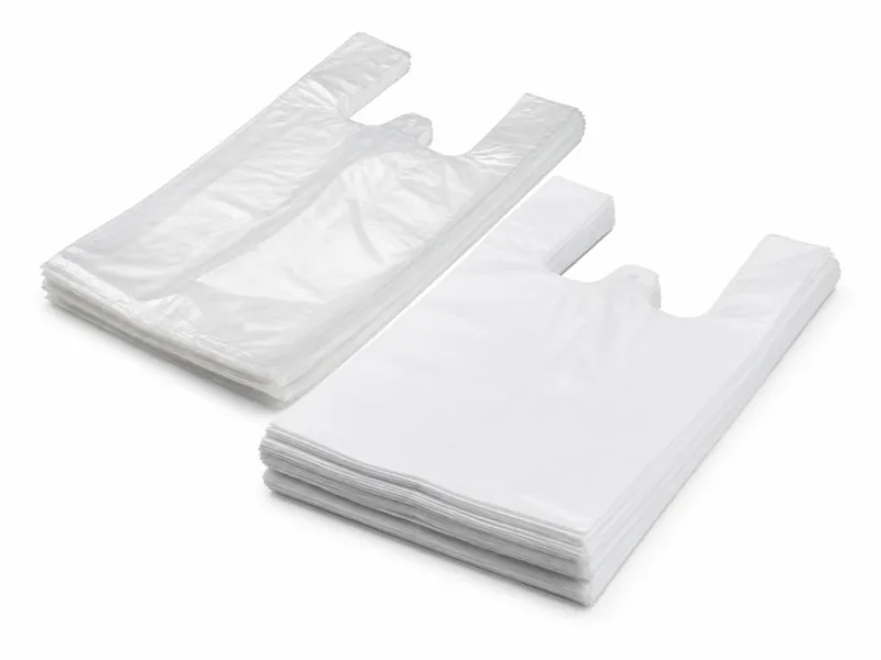 Bolsas camiseta blancas y transparentes apiladas sobre fondo blanco